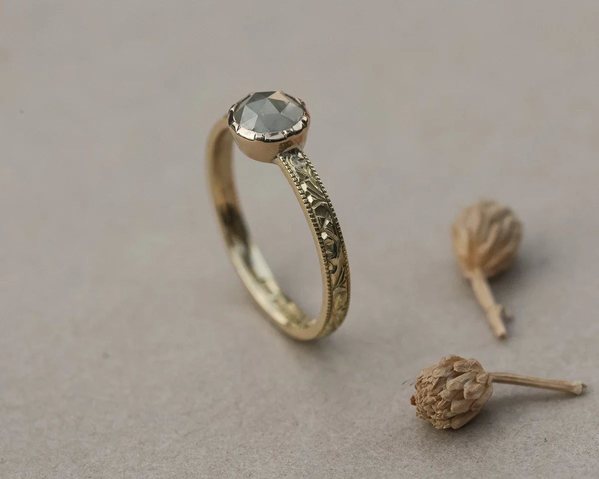 Side view of pale grey rose-cut diamond ring with floral engraved band