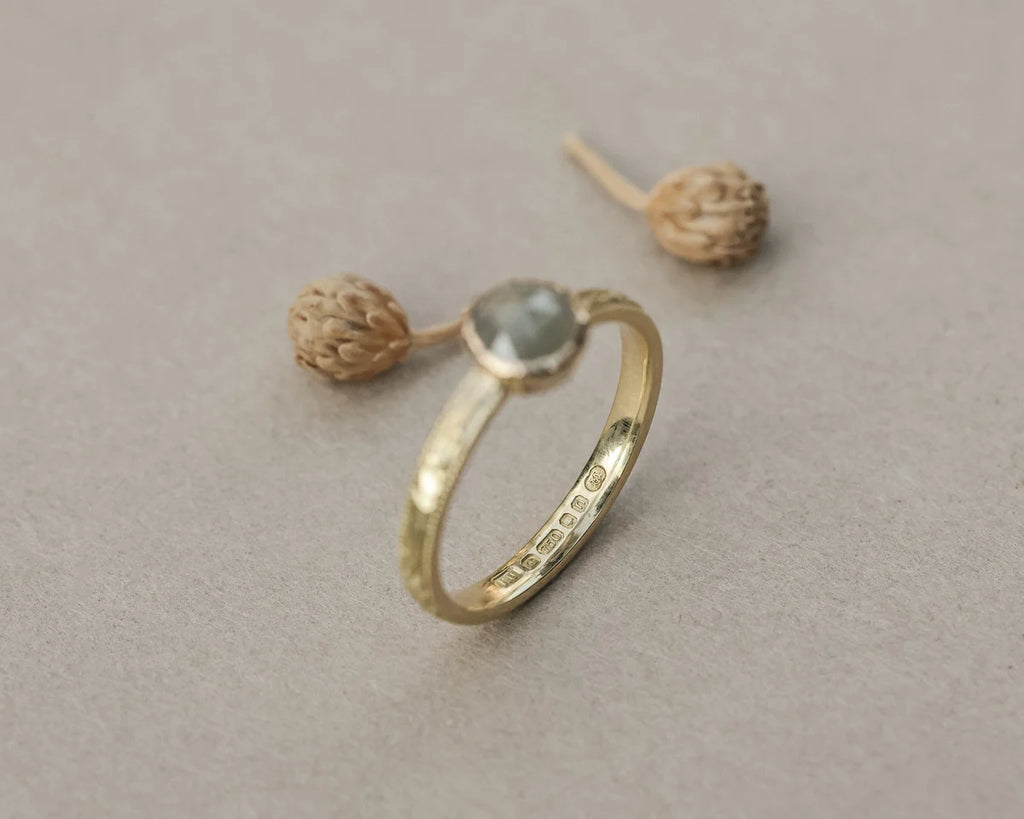 Side profile of pale grey rose-cut diamond ring in yellow gold