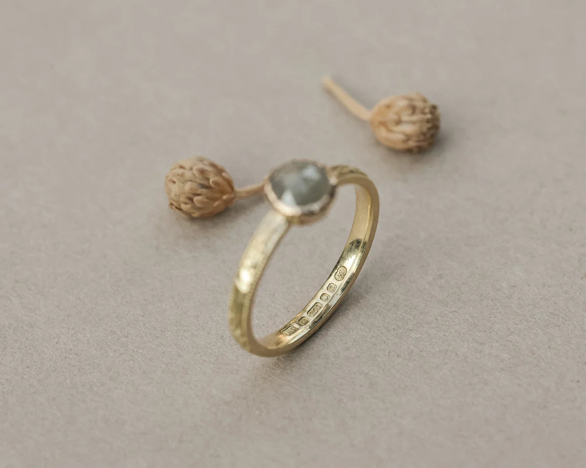 Side profile of pale grey rose-cut diamond ring in yellow gold