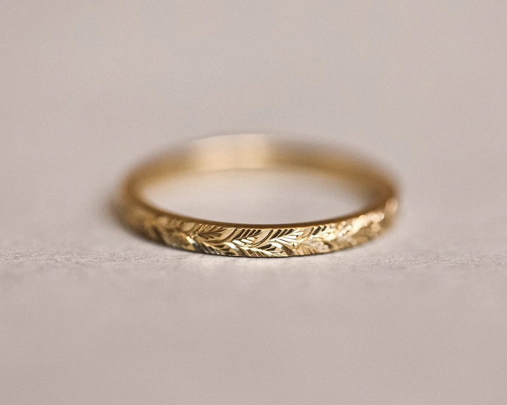 Low front view of laurel leaf engraved yellow gold wedding ring
