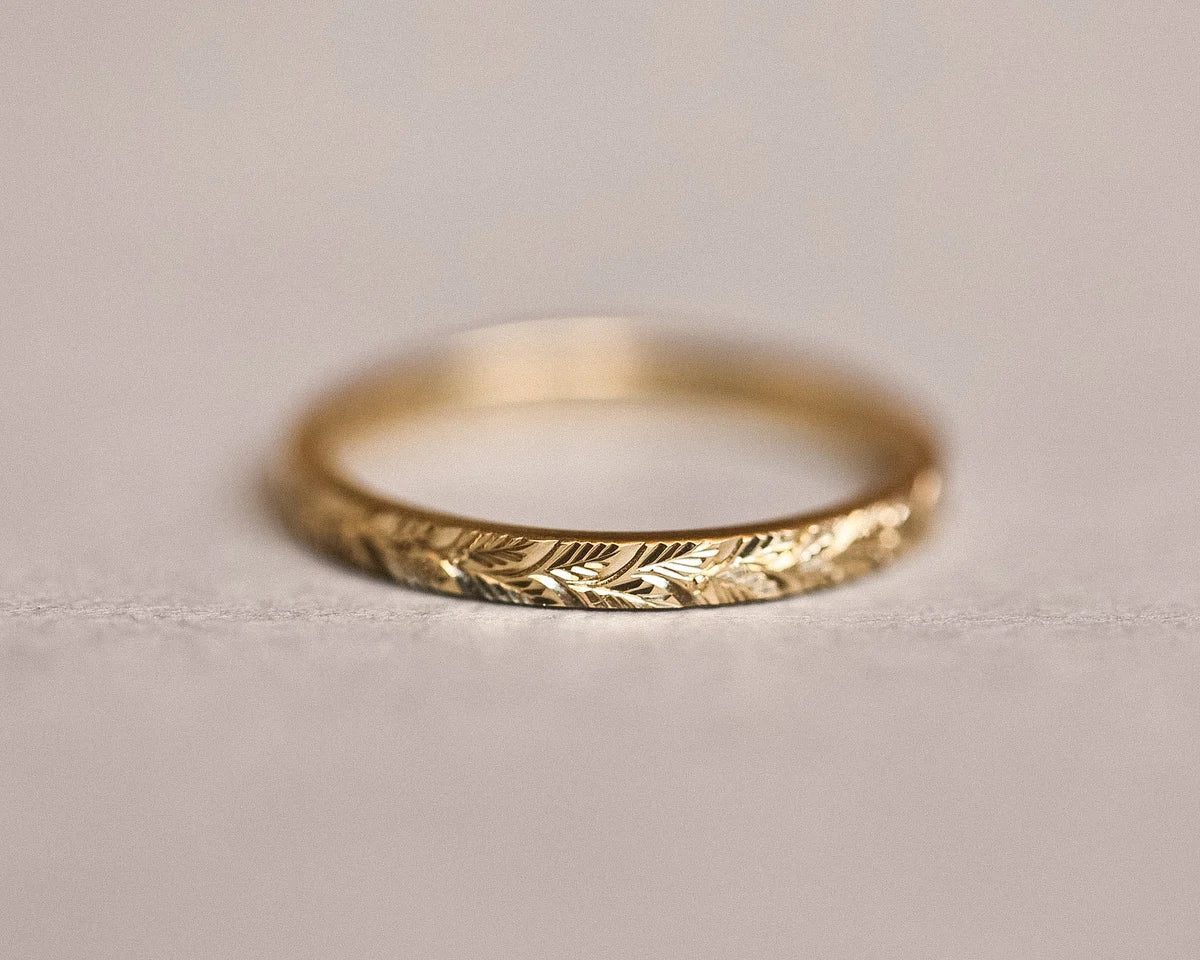 Low front view of laurel leaf engraved yellow gold wedding ring