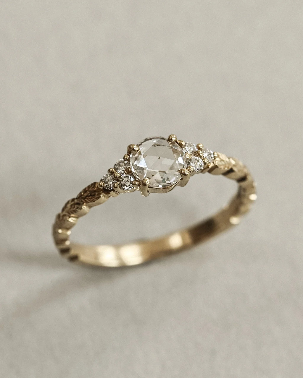 Angled close-up of rose-cut diamond ring with laurel leaf band