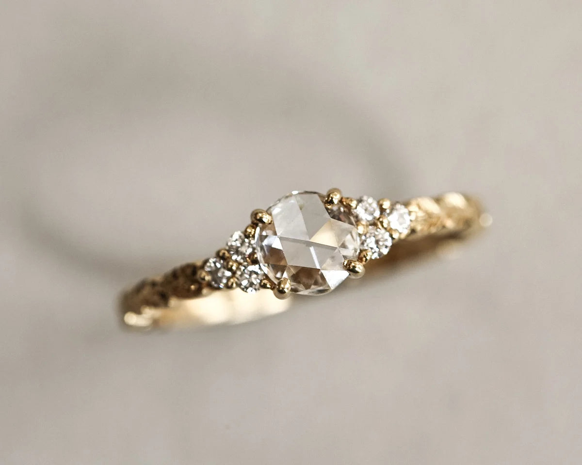 Close-up of 5mm rose-cut diamond with hand carved laurel band