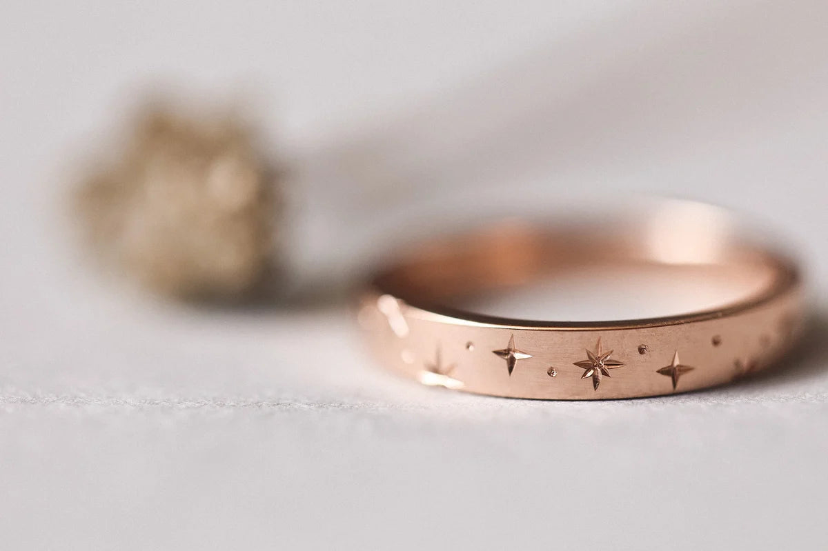 Close-up of hand engraved star motif on 18ct rose gold band