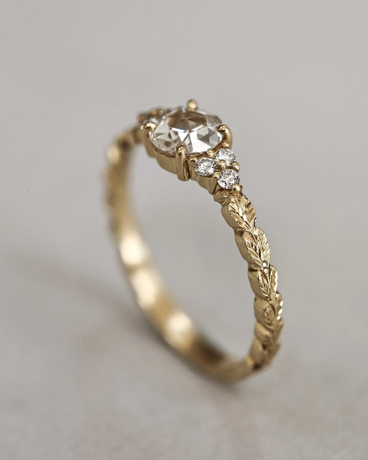 Vertical view of 18ct yellow gold laurel leaf ring with side diamonds