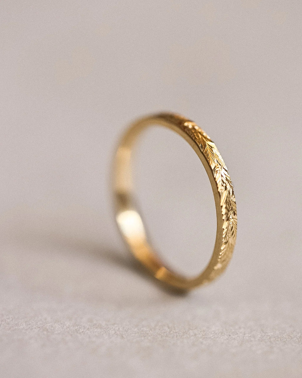 Angled view of 2mm yellow gold laurel leaf wedding band