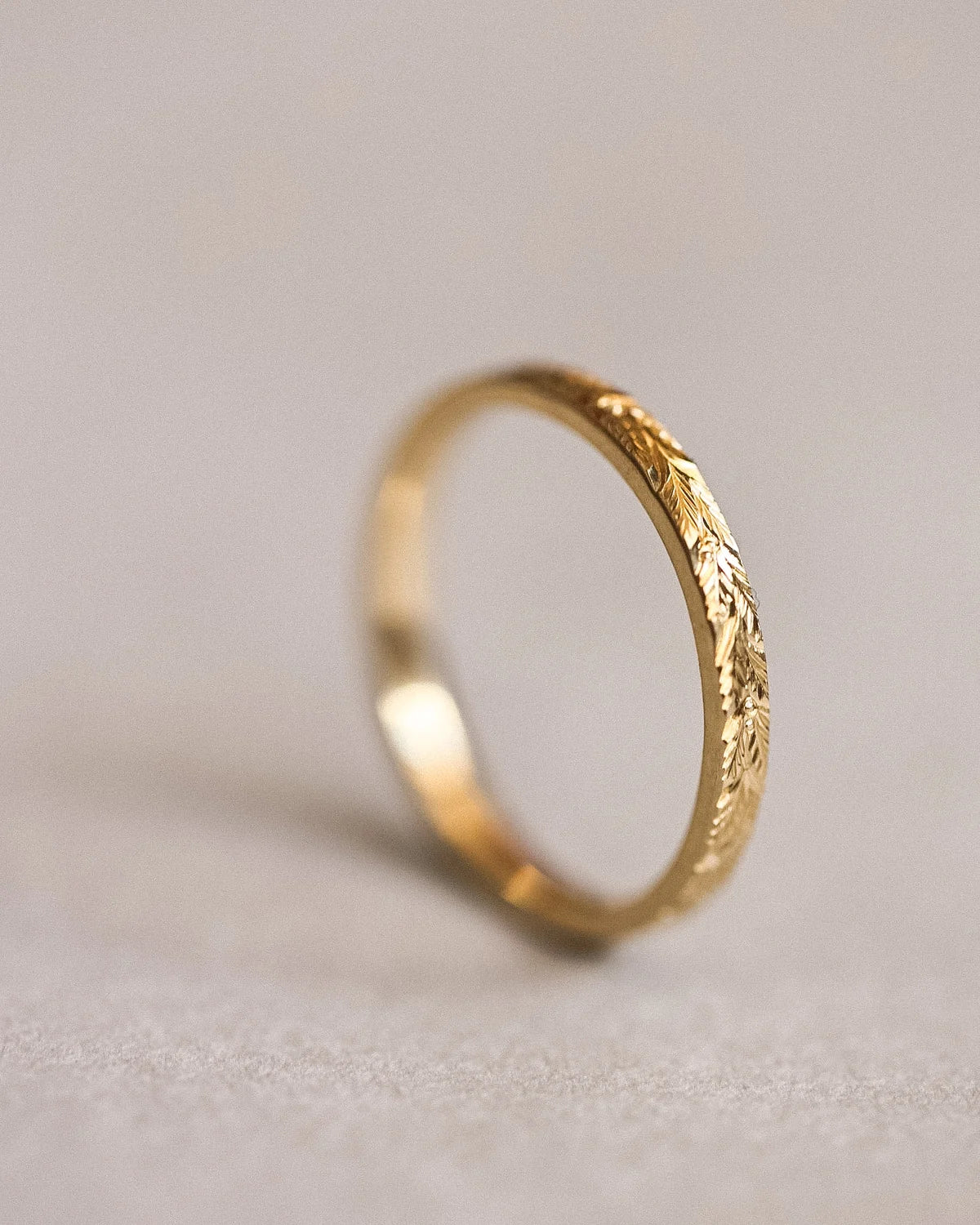 Angled view of 2mm yellow gold laurel leaf wedding band