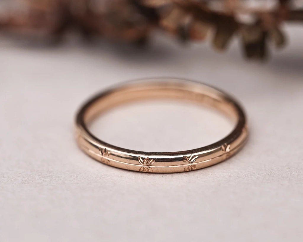 Rose gold ring with intricate design on a light background