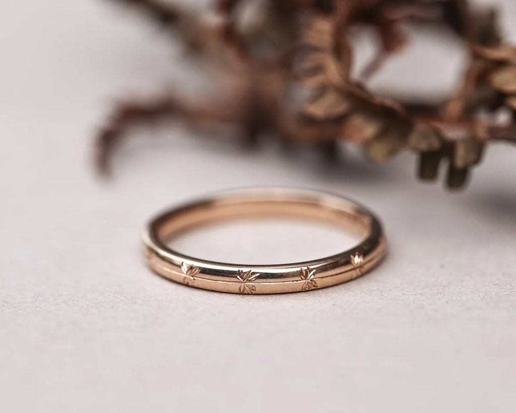 Rose gold ring with engraved details on a light background