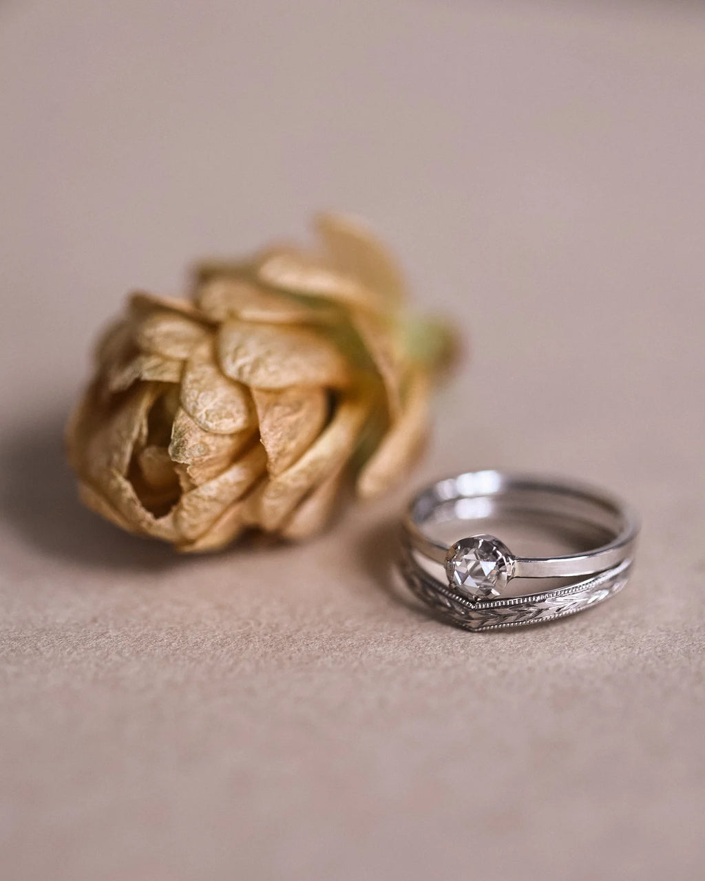 Rose-cut diamond ring in platinum shown beside dried flower