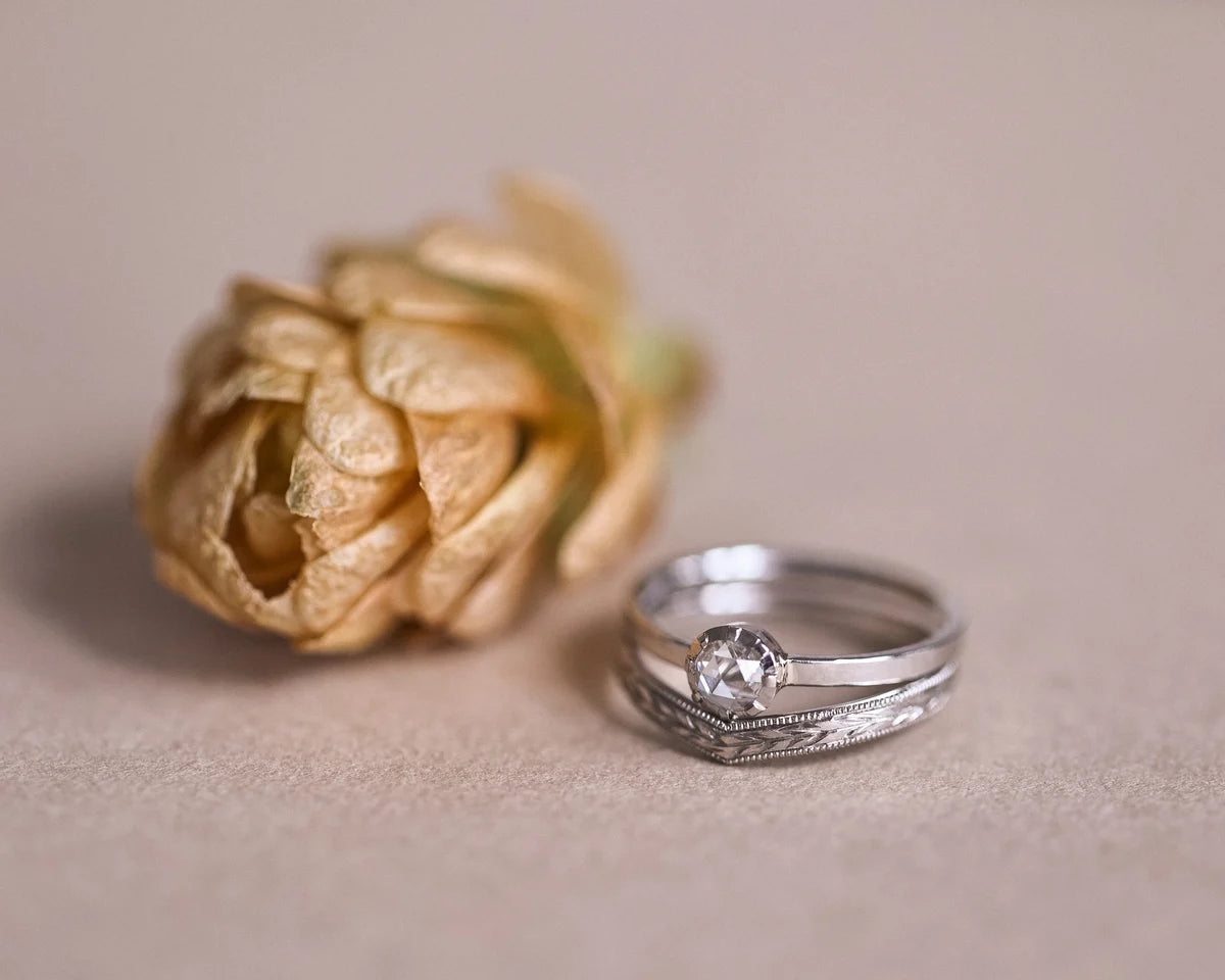 Platinum rose-cut diamond ring paired with pavé wishbone wedding band