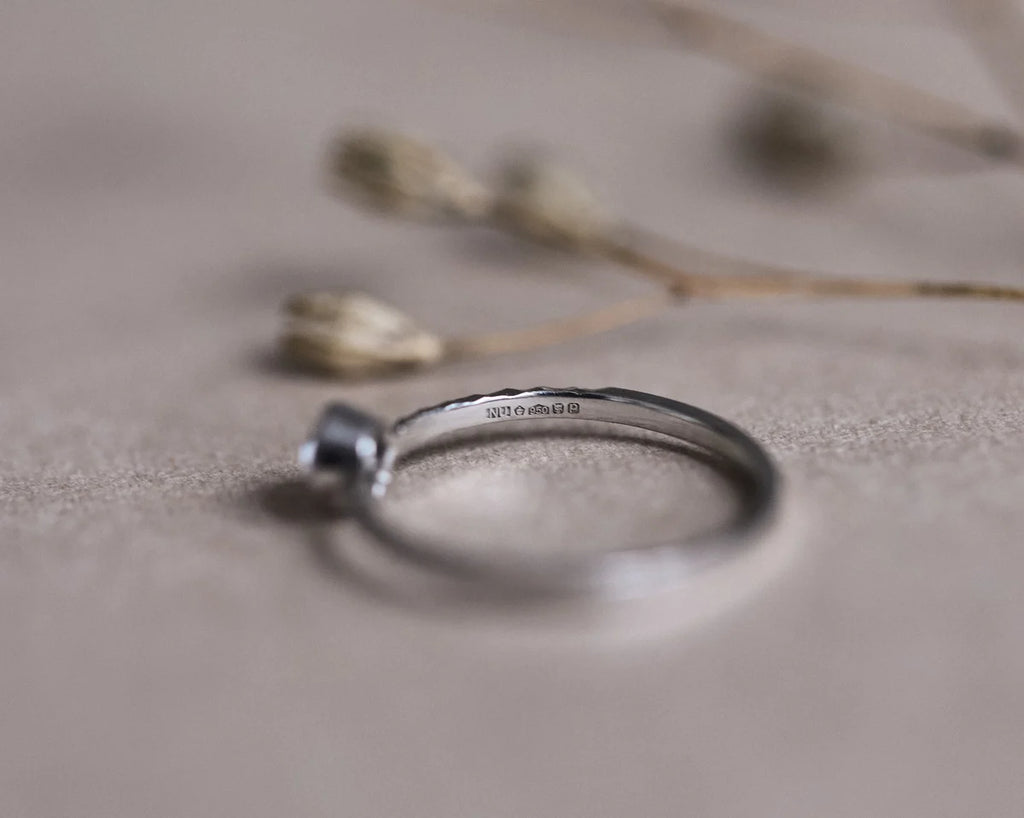 Close-up of platinum faceted ring with white rose-cut diamond