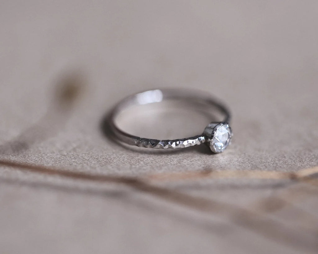 Low front view of platinum faceted ring with rose-cut diamond