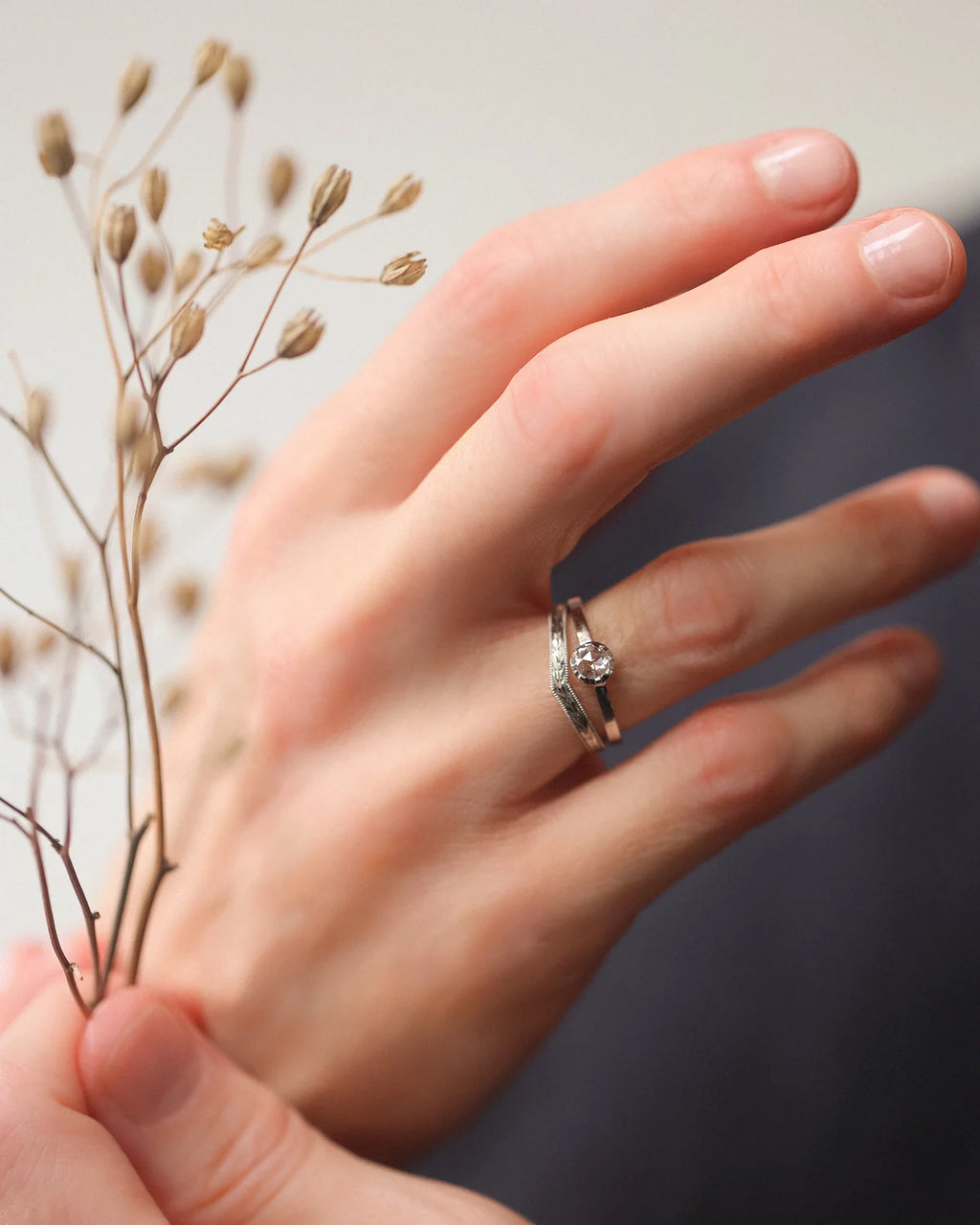Platinum rose-cut diamond ring worn on hand with soft botanical styling