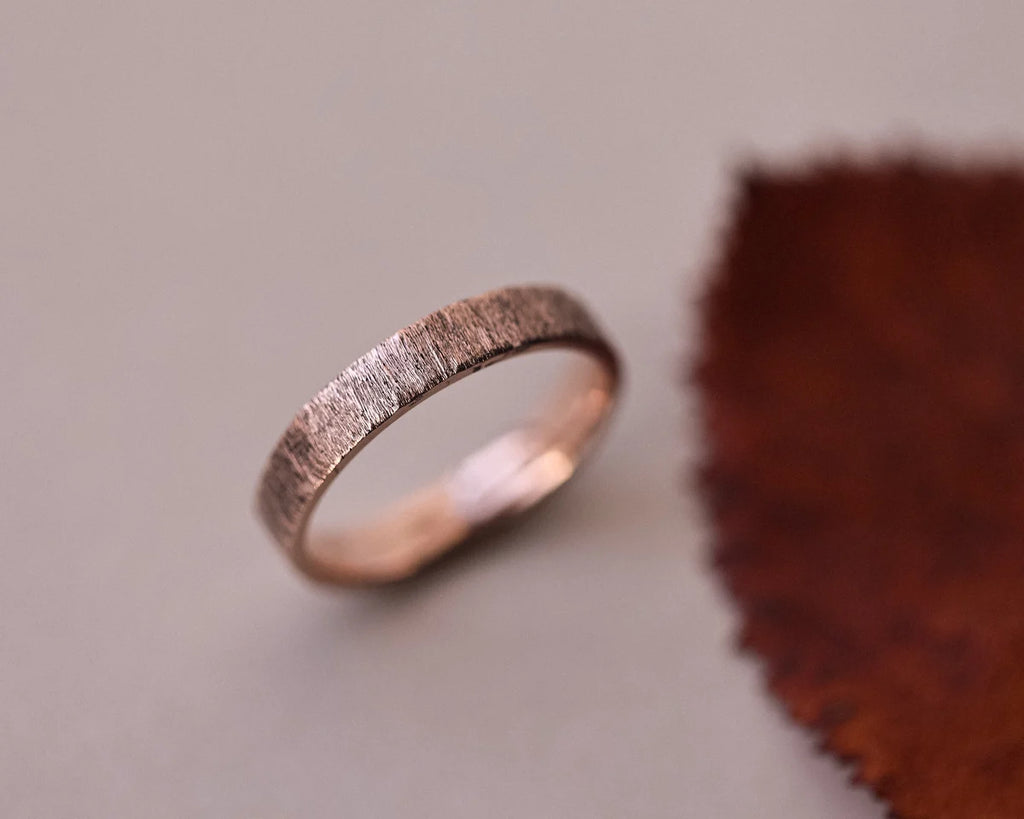 4mm flat court wedding ring in 9ct rose gold with a hand finished horn texture. Handmade in London and made to order.