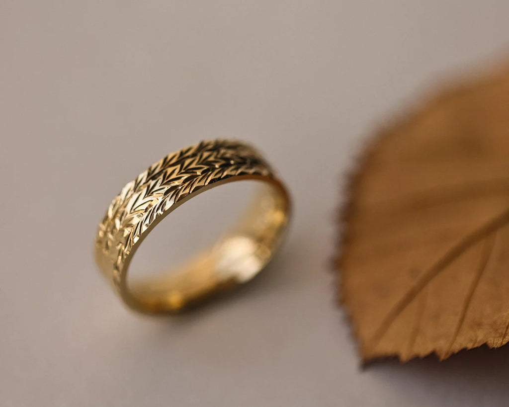 Side view of hand engraved herringbone wedding ring in 18ct yellow gold