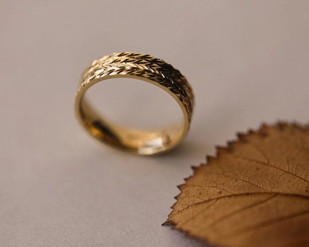 Angled view of 18ct yellow gold herringbone engraved wedding ring