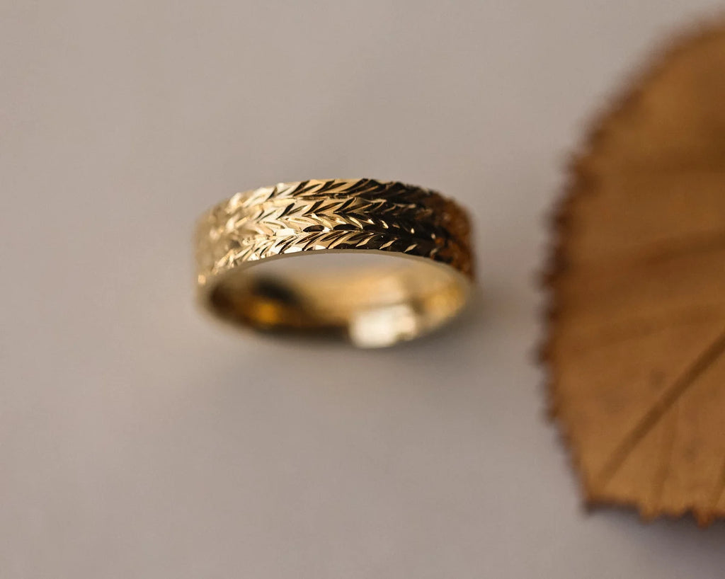 Front view of 6mm herringbone wedding band in yellow gold