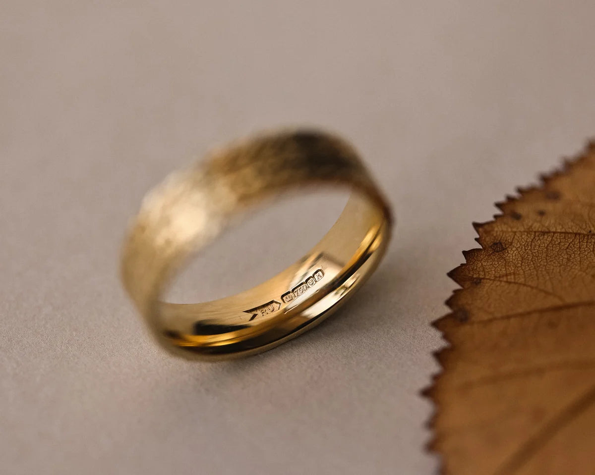 Front view of 6mm herringbone wedding band in yellow gold