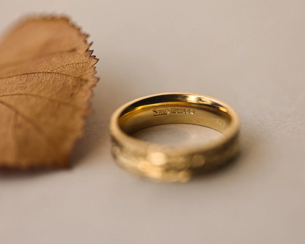 Inside view of 18ct yellow gold flat court wedding ring with hallmark