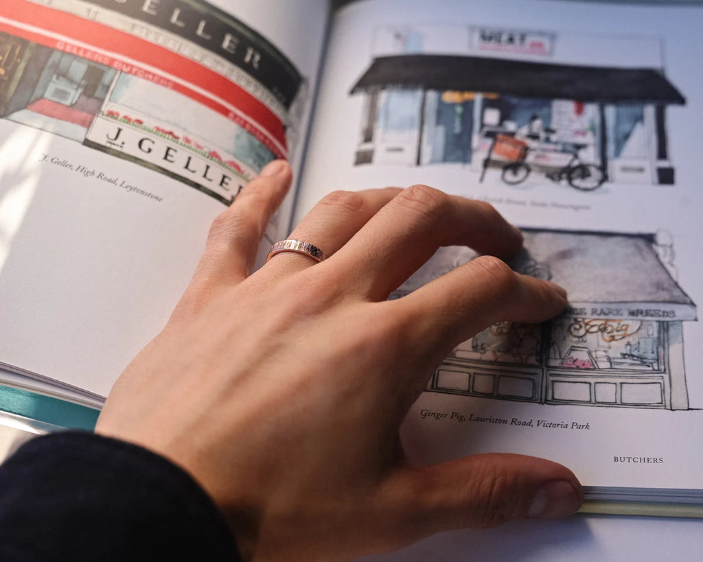 Horn texture rose gold wedding ring worn while reading illustrated book