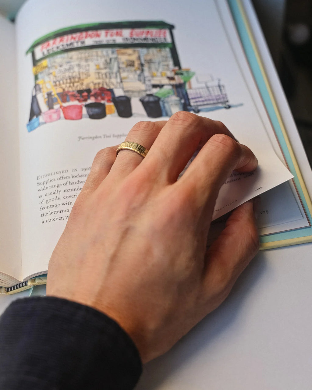 Horn texture wedding ring worn on hand while reading illustrated book