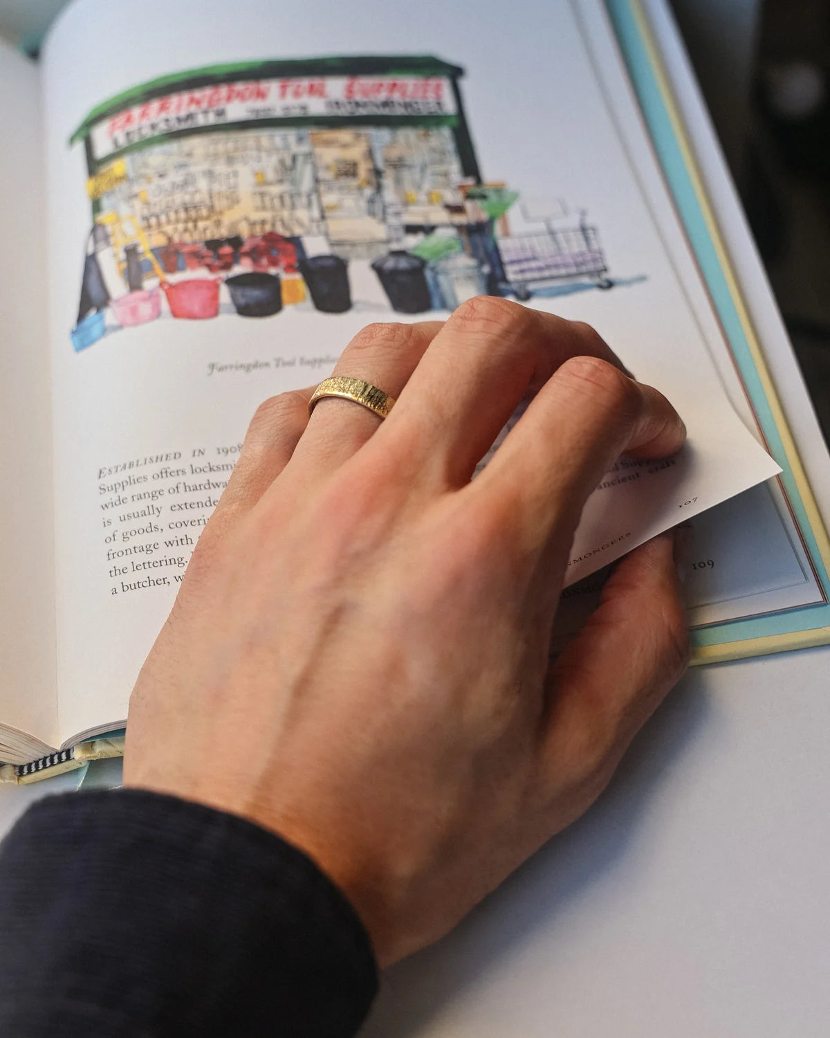 Horn texture wedding ring worn on hand while reading illustrated book