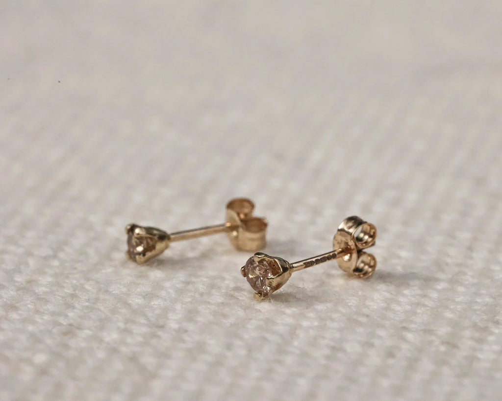 rose gold  champagne diamond 
stud side view on beige fabric