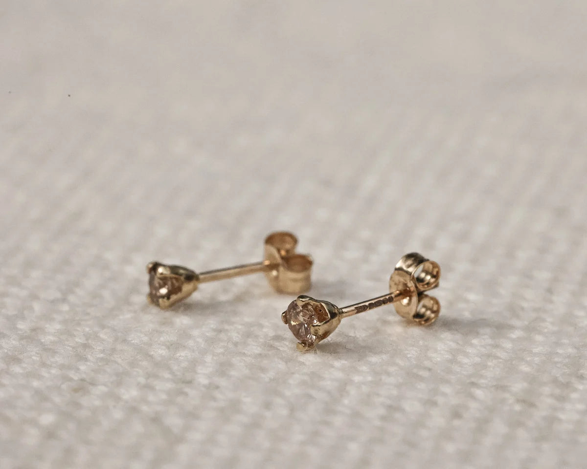 rose gold  champagne diamond 
stud side view on beige fabric