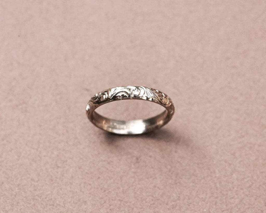 Angled view of 18ct white gold floral engraved wedding band