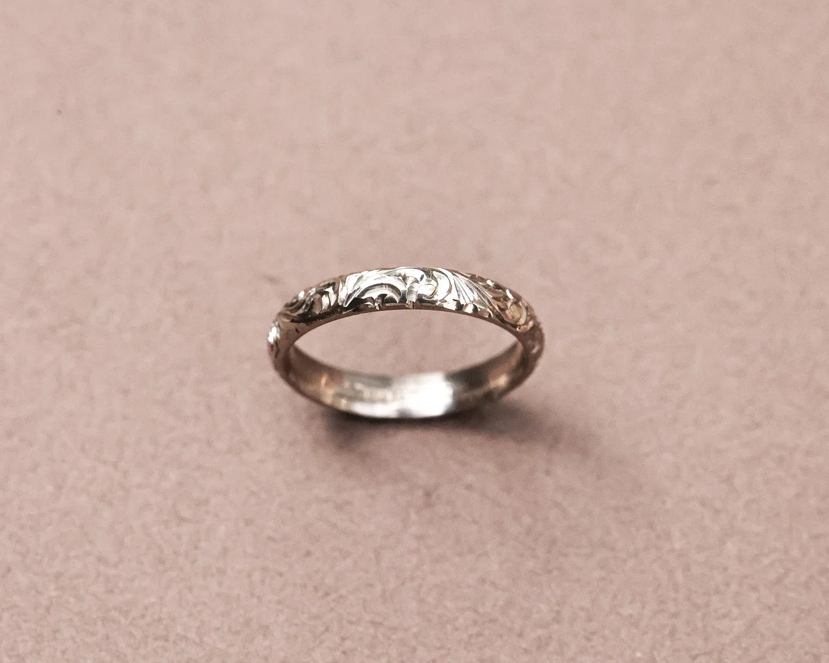 Angled view of 18ct white gold floral engraved wedding band