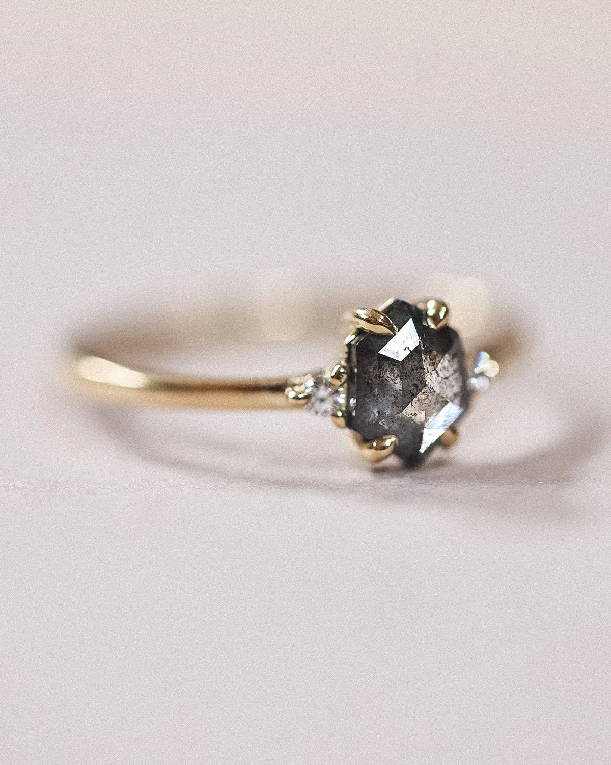 Front view of handmade grey diamond trilogy ring in yellow gold