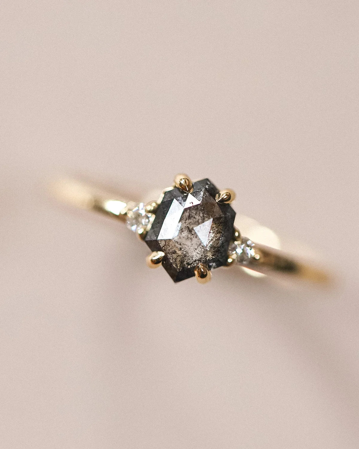  Soft focus close-up of grey rose-cut diamond trilogy ring