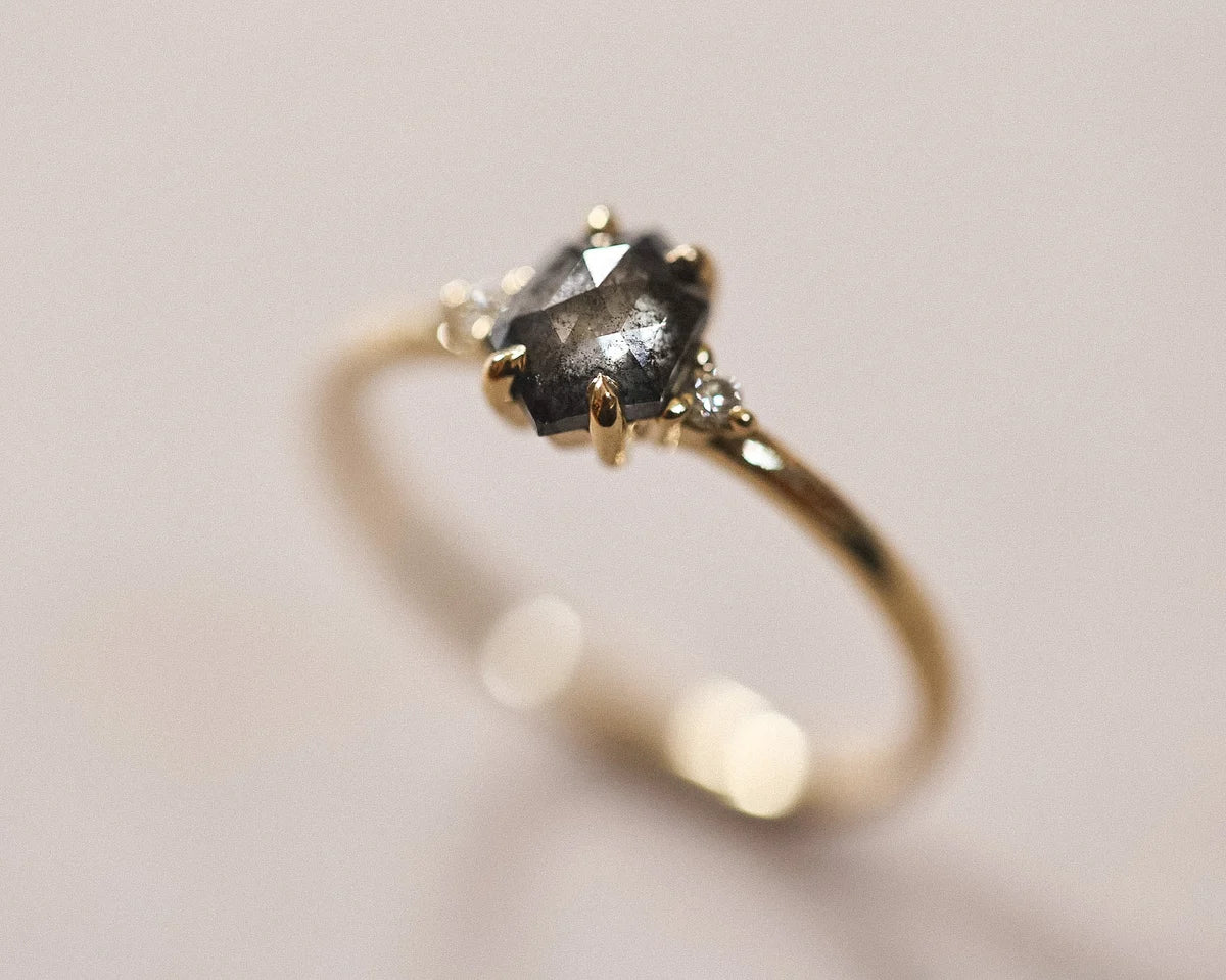 Angled view of the grey diamond trilogy ring with white diamond shoulders