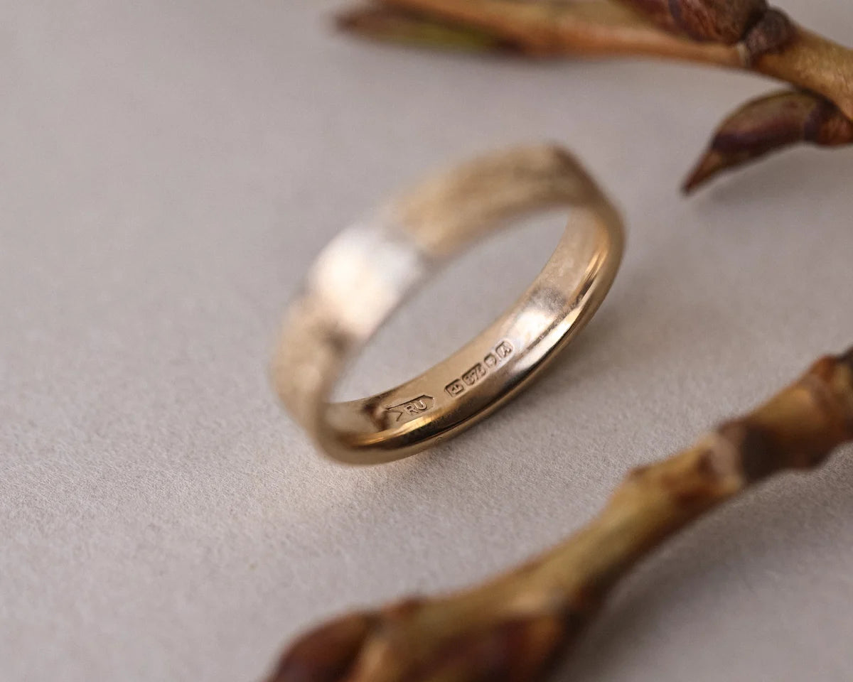Detailed view of fir engraving on 9ct yellow gold flat court ring