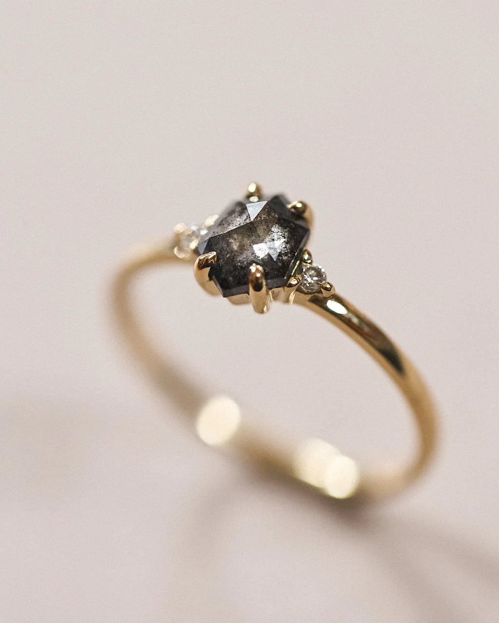 Side profile of grey rose-cut diamond trilogy ring in 18ct yellow gold