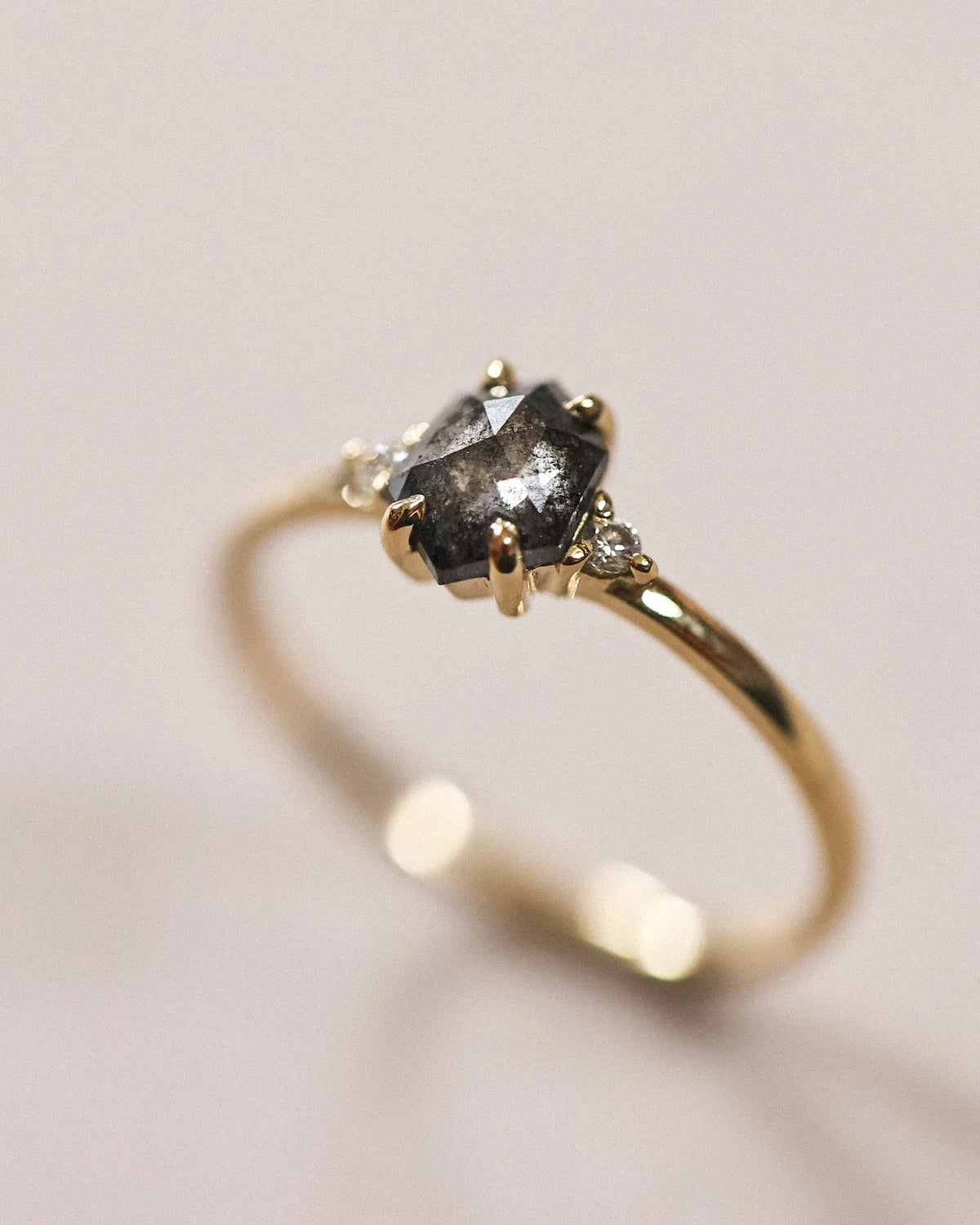 Side profile of grey rose-cut diamond trilogy ring in 18ct yellow gold