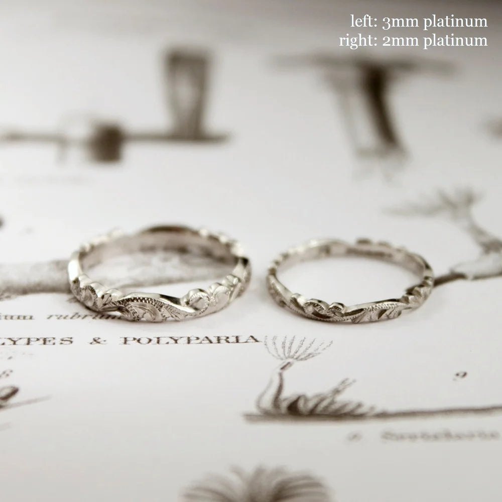 Two platinum rings on a decorative background with text