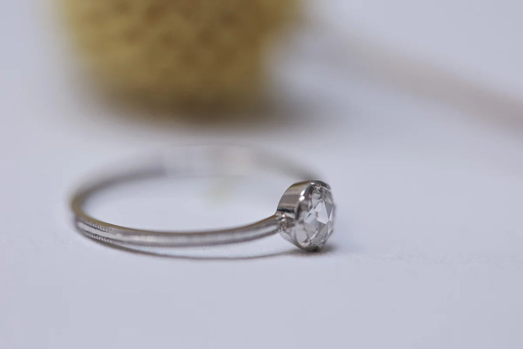 Silver ring with a diamond on a blurred background