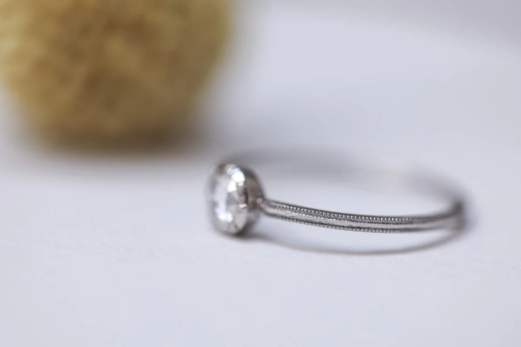 Silver ring with a textured band on a light background