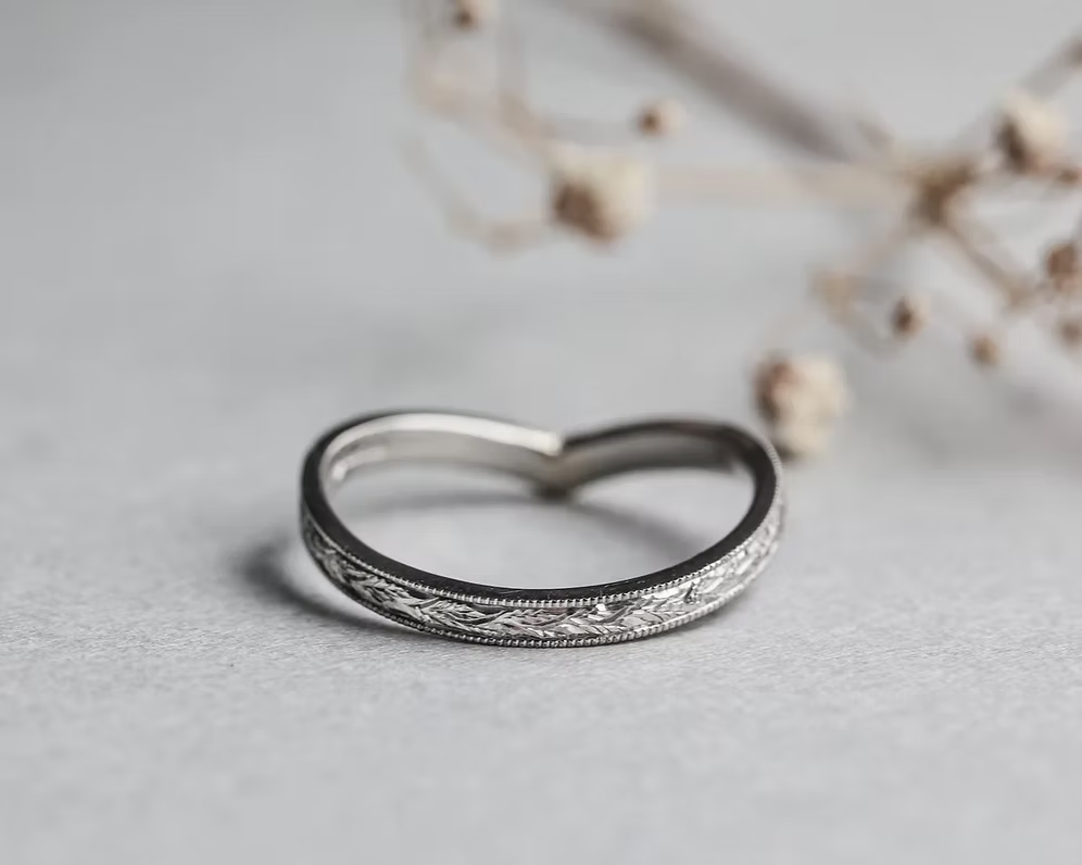Silver ring with intricate design on a light gray background