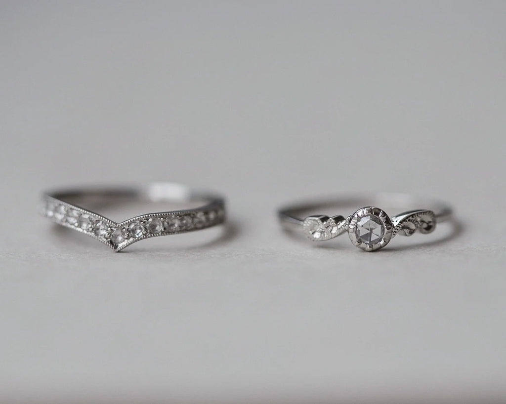 Two silver rings with diamond accents on a light gray background