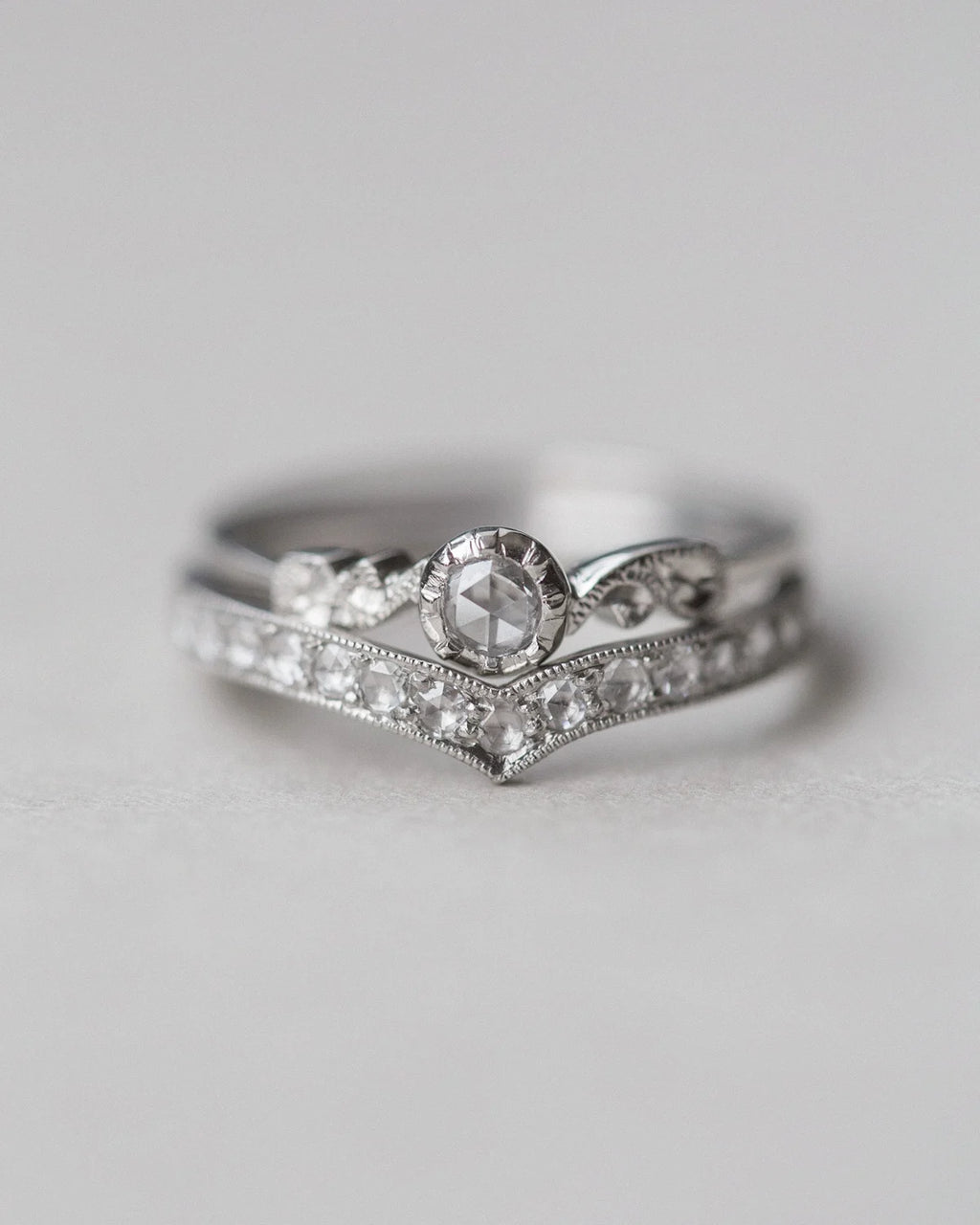 Two diamond rings stacked on a light gray background