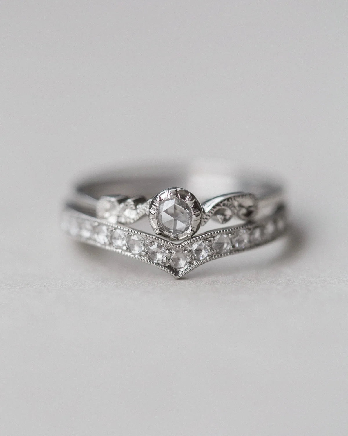 Two diamond rings stacked on a light gray background