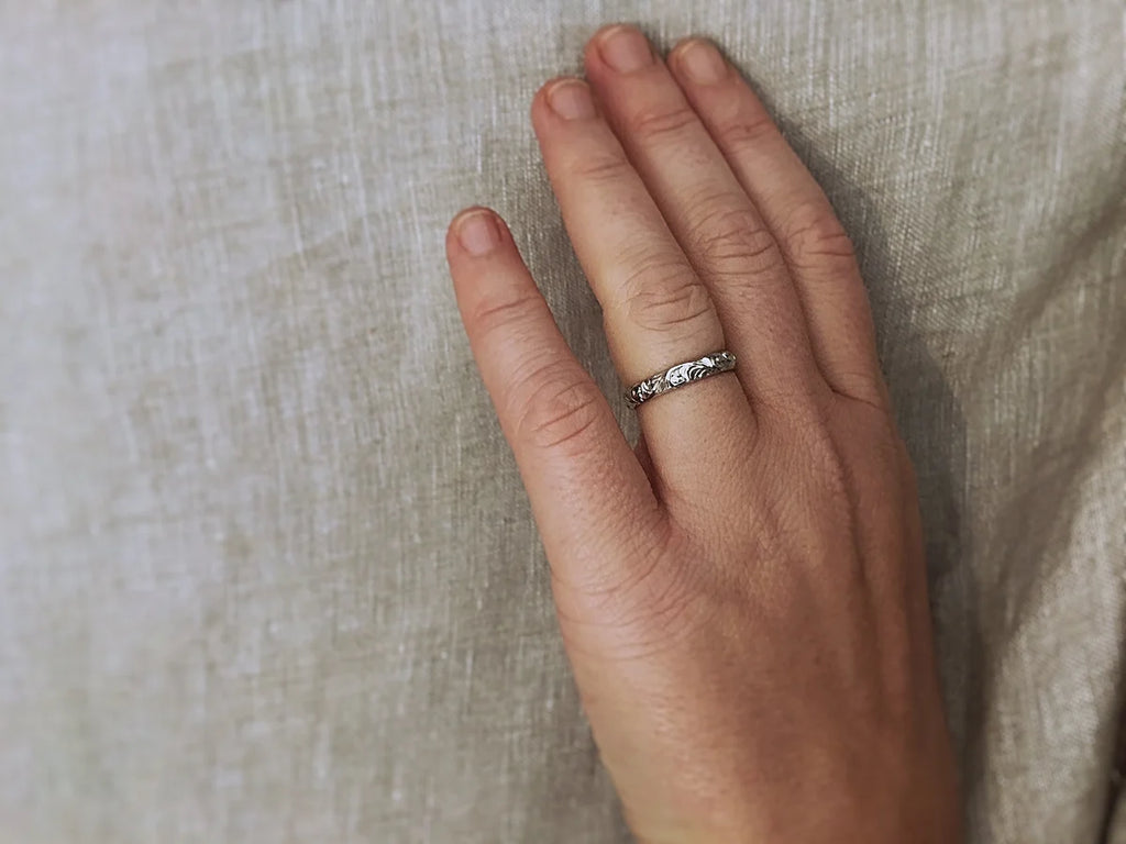 18ct white gold floral engraved wedding ring worn on hand