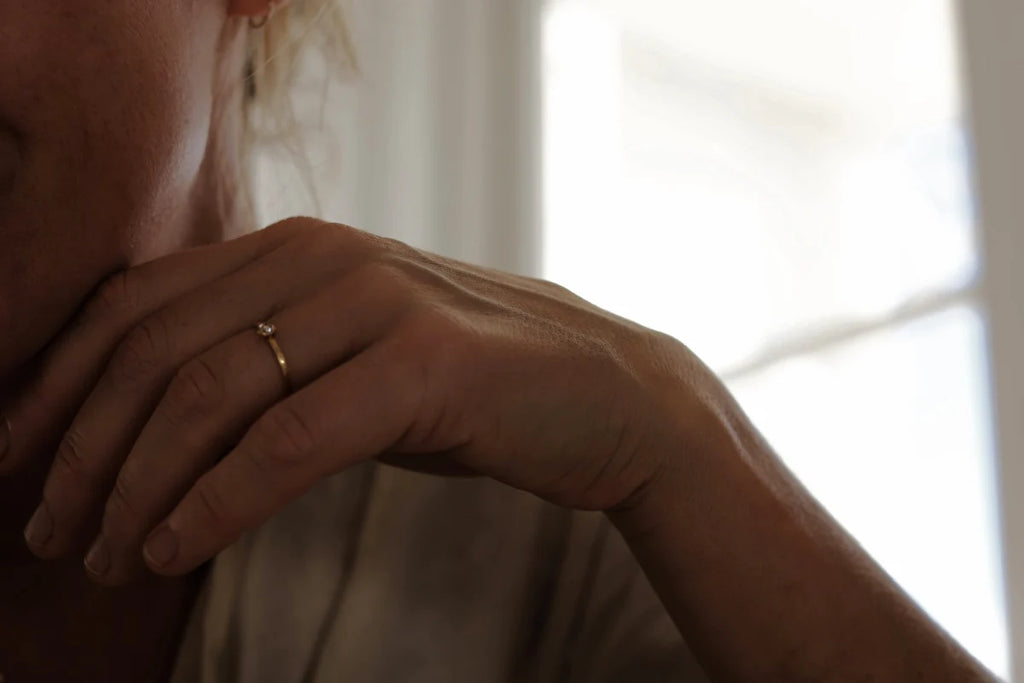 Close-up of a hand with a ring on a blurred background