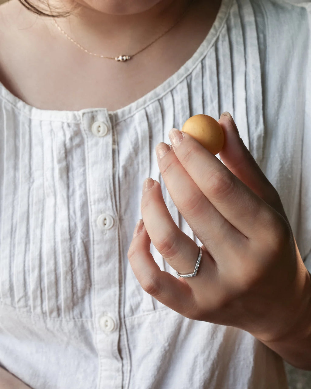 platinum wishbone ring worn alongside solitaire engagement ring