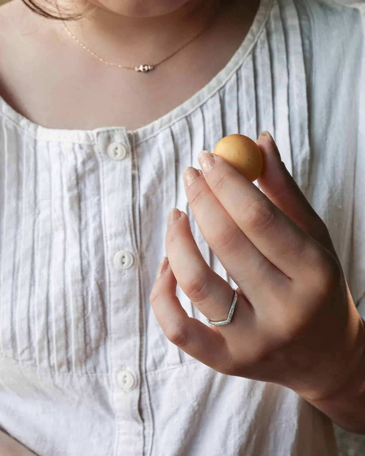 platinum wishbone ring worn alongside solitaire engagement ring