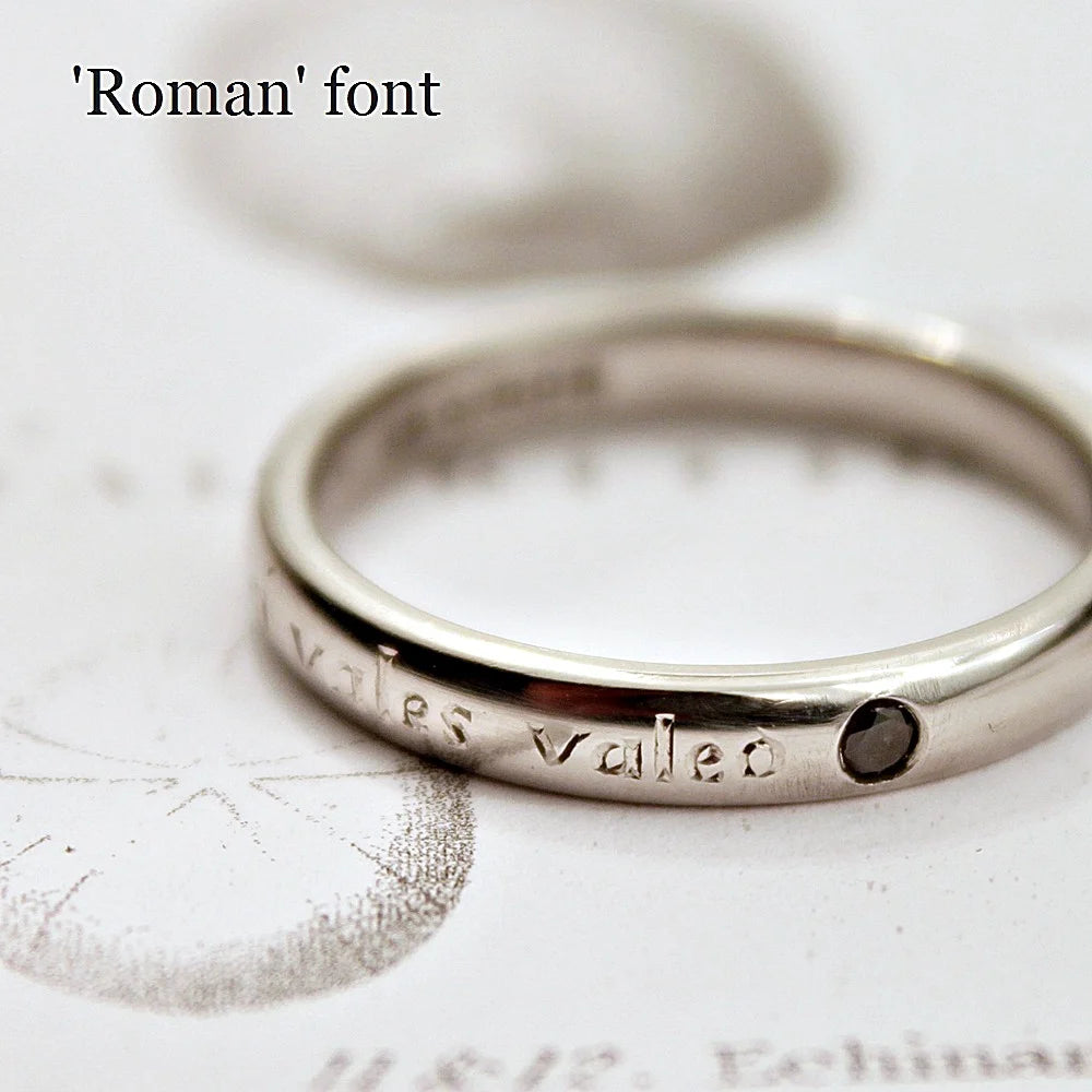 Silver ring with 'valles valae' engraving on a textured surface