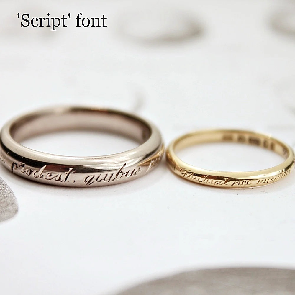 Two rings with 'script' font engraving on a white background